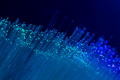 A DSLR close-up photo of fiber optics in blue tones. Space for copy.