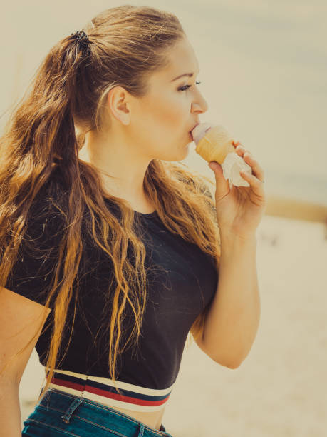 istock Young woman eating ice cream 1349632701
