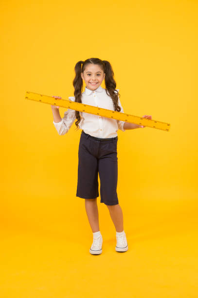 istock School student study geometry. Tell me about distance. Kid school uniform hold ruler. Pupil cute girl with big ruler. Geometry school subject. Education and school concept. Sizing and measuring 1349639845