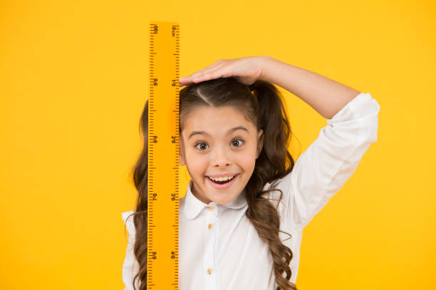 I am still growing. Tall kid. Kid school uniform hold ruler. Pupil cute girl with big ruler. Geometry school subject. Education and school concept. Sizing and measuring. School student study geometry. todavía estoy creciendo. niño alto. el uniforme escolar de los niños sostiene la regla. alumna linda chica con regla grande. asignatura de geometría escolar. educación y concepto escolar. dimensionamiento y medición. estudiante de la escuela estudia