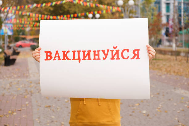 istock A woman holds a poster with text, translated from Ukrainian: Get vaccinated 1349642558