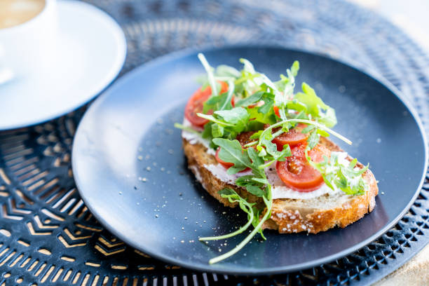 istock A cup of coffee and sandwich with vegetables on a black plate. 1349646873
