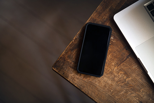 Top view mockup telephone device screen on a wooden table