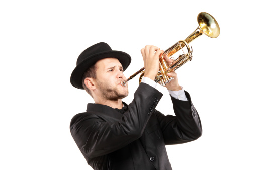 A man in a suit with a hat playing a trumpet isolated on white background