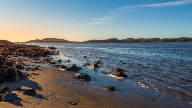 Sunset over a Scottish coastline in winter at a sandy beach at Kirkcudbright Bay stock photo