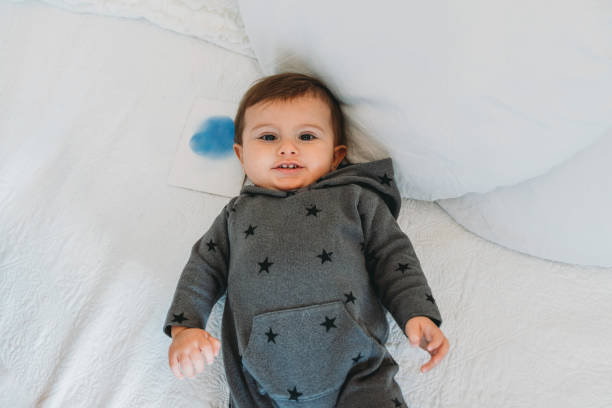 istock Cute little kid is lying down on the bed, looking at camera 1349661623