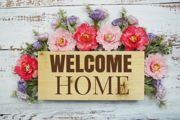 Welcome Home text with flowers frame decprate on wooden background