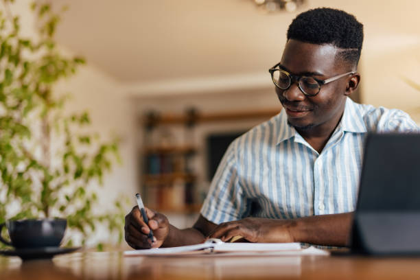 istock Adult black man, writing down his thoughts. 1349661861