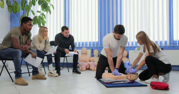 instructor masculino enseñando técnica de cpr de primeros auxilios a sus alumnos. - cpr first aid paramedic rescue fotografías e imágenes de stock