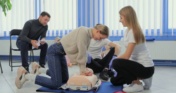 mujer demostrando rcp en maniquí en clase de primeros auxilios. - cpr first aid paramedic rescue fotografías e imágenes de stock