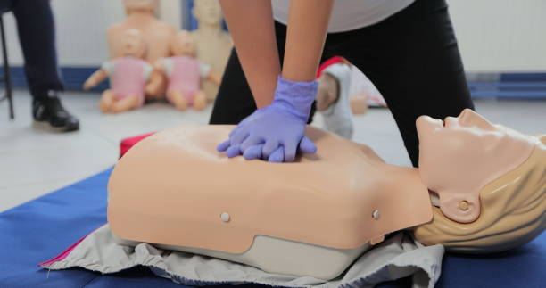 istock Woman demonstrating CPR on mannequin in first aid class. 1349671125