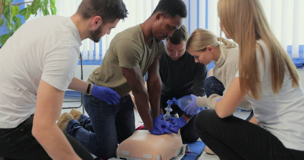 Closeup of students practicing CPR chest compression on dummy. Closeup of students practicing CPR chest compression on dummy cpr stock pictures, royalty-free photos & images