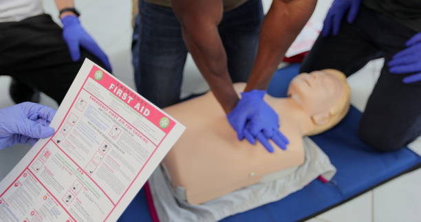 concetto di formazione di primo soccorso cpr. vista posteriore della donna che tiene l'istruzione di primo soccorso durante la lezione di formazione cpr. - cassetta di pronto soccorso foto e immagini stock