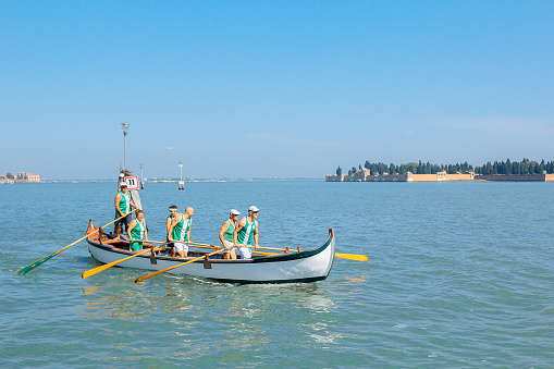 Venice, Italy - July 28, 2013: Team of athletes rowers floats in boat on Grand Canal, Venice, Italy