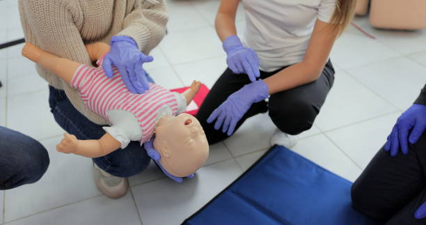 primo piano dell'istruttore di primo soccorso che utilizza un manichino per bambini che dimostra come salvare un bambino soffocante. - soffocare foto e immagini stock