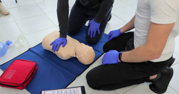 istock Closeup of students practicing CPR chest compression on teen dummy. 1349671698