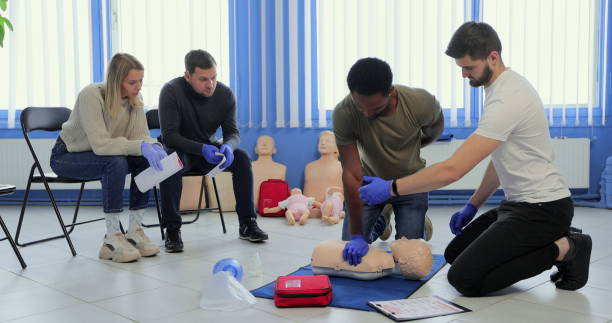 istock Group of people CPR First Aid Training course. CPR teen dummy first aid training. 1349671775