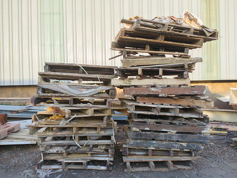 piles of wooden pallets that cannot be used because they are dirty and damaged