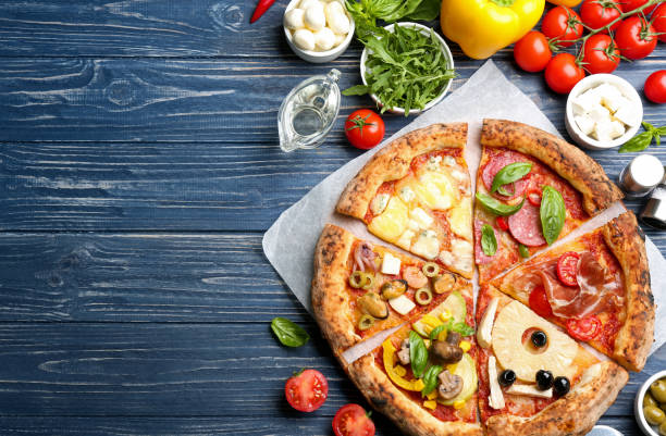 istock Slices of different pizzas on blue wooden table, flat lay. Space for text 1349673558