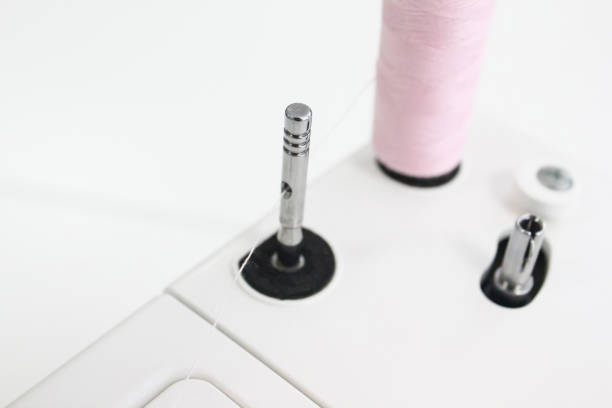 A bright and organized sewing room filled with various supplies including colorful threads, ribbons, and sewing machines. The room features a comfortable chair with a butterfly pattern, a large red heart on the wall, and a neatly arranged workspace perfect for crafting and sewing projects.