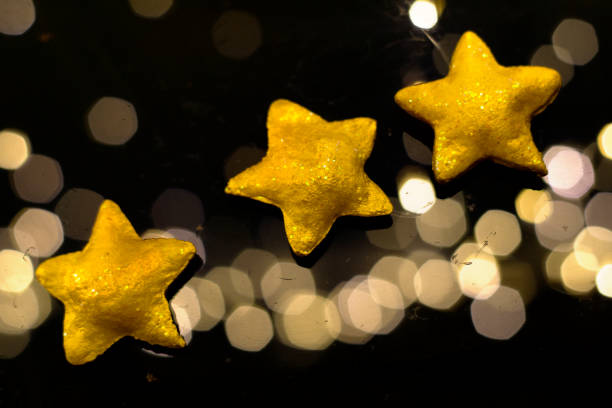 istock Three golden stars with a festive background 1349674738