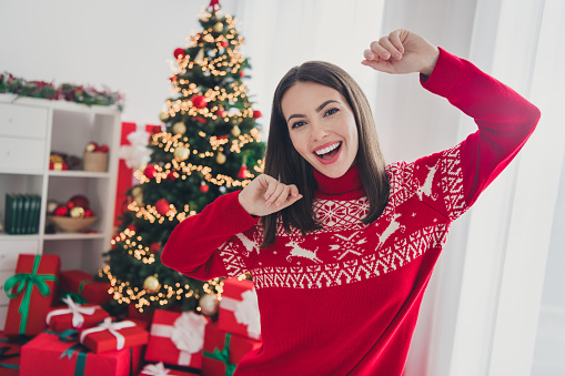 Photo of carefree funny positive lady dance noel tradition party wear sweater in decorated x-mas home indoors