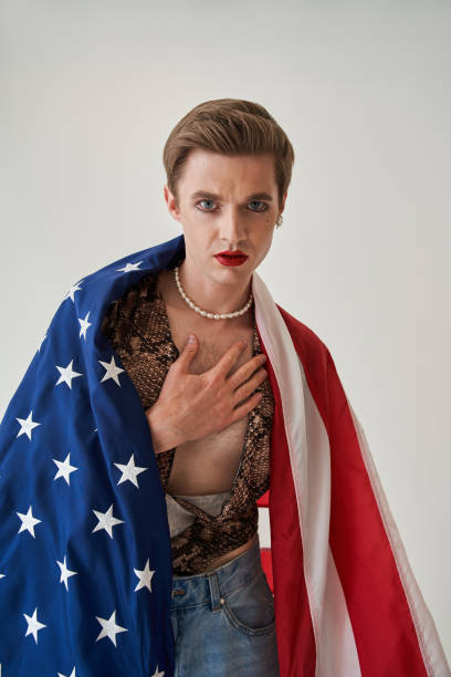 istock Man with bright make up holding his hand at the chest while looking at the camera 1349675185