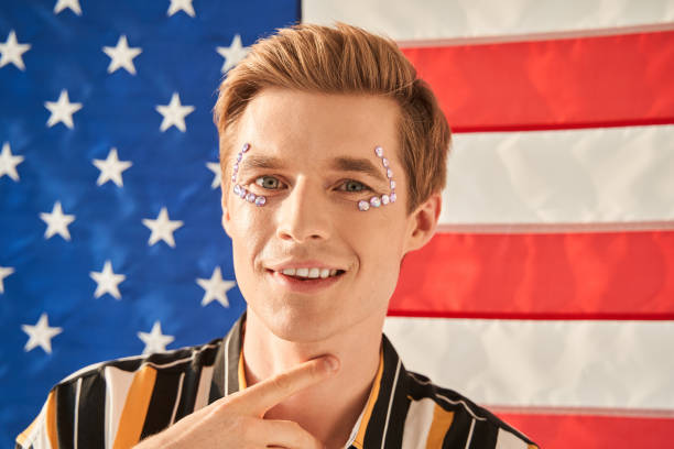 istock Male model with rhinestones on face smiling and looking at camera cunning 1349675306
