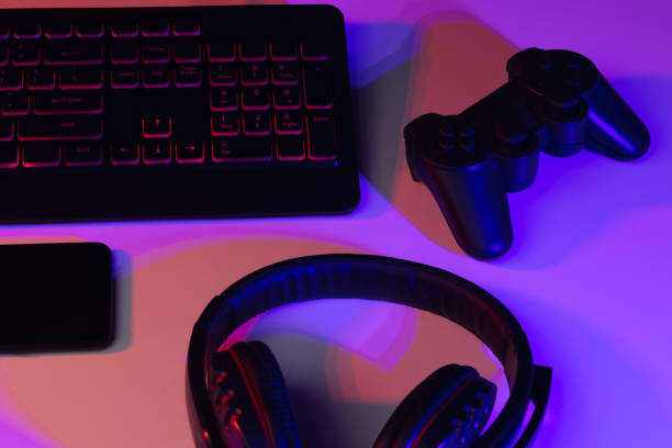 istock Accessory gaming keyboard joystick mouse headphone with blank space. Gadget for gamer playing video game online in the neon light darkroom. 1349678552