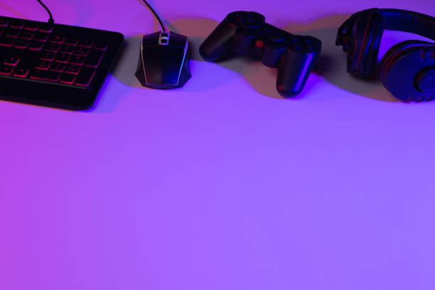 istock Accessory gaming keyboard joystick mouse headphone with blank space. Gadget for gamer playing video game online in the neon light darkroom. 1349678569