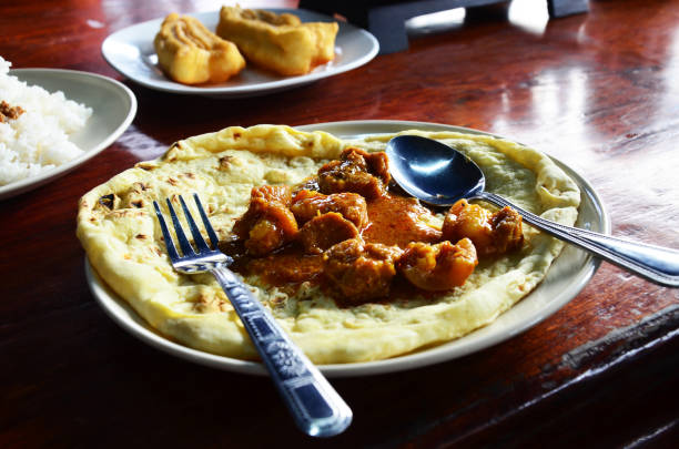 Breakfast traditional indian food southern flat bread or roti with beef or chicken massaman curry at local restaurant of market in morning time at Sangkhla Buri city in Kanchanaburi, Thailand