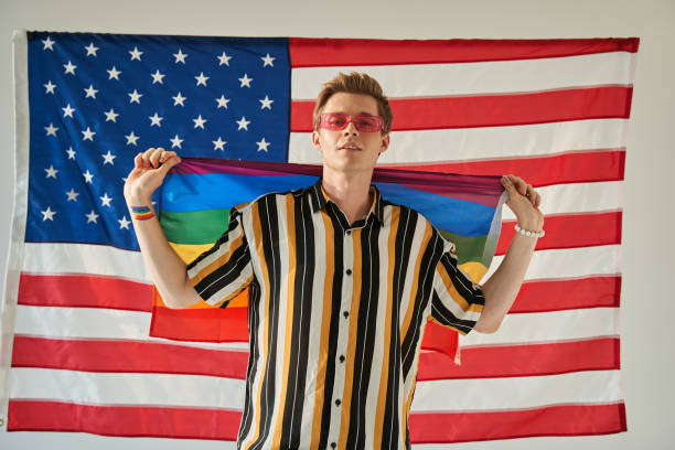 istock Man showing lgtbi flag while posing with USA flag at the background 1349679733