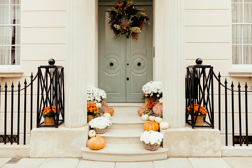 Front porch of a house with Halloween decorations including pumpkins.