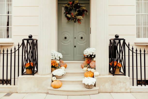 Pumpkins on front steps of houses decorated for Halloween Front porch of a house with Halloween decorations including pumpkins. front porch stock pictures, royalty-free photos & images