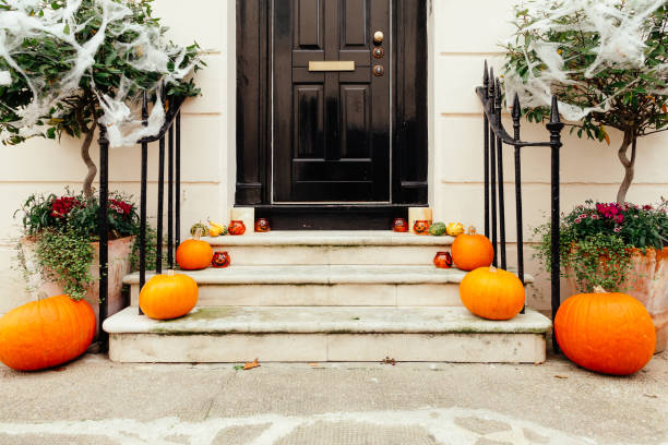 istock Pumpkins on front steps of houses decorated for Halloween 1349682367