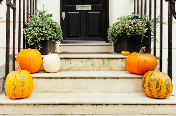 istock Pumpkins on front steps of houses decorated for Halloween 1349682368