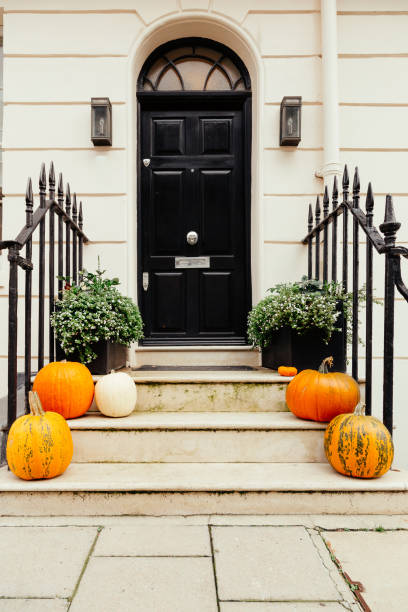 istock Pumpkins on front steps of houses decorated for Halloween 1349682404