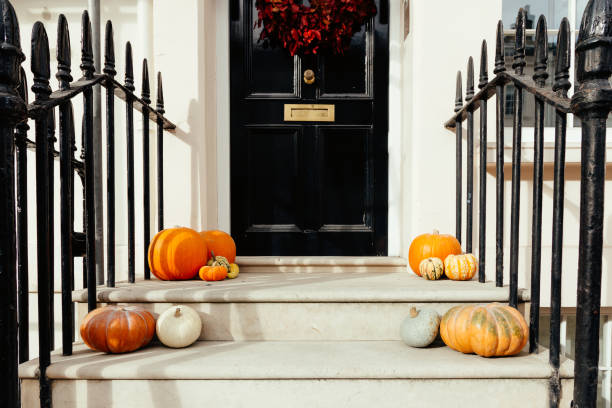 istock Pumpkins on front steps of houses decorated for Halloween 1349682421