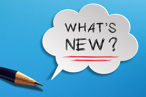 What's New written in speech bubble with pencil on blue background