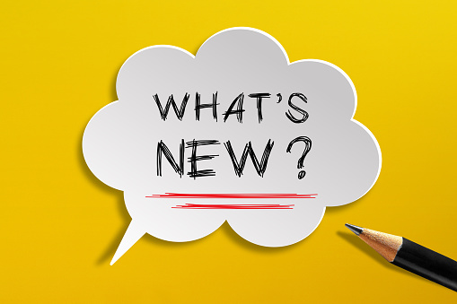 What's New written in speech bubble with pencil on yellow background