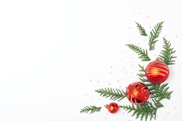 istock Minimalistic Christmas composition, frame. Red Christmas balls and green branches of thuja on white background. Copy space, flat lay. 1349685988