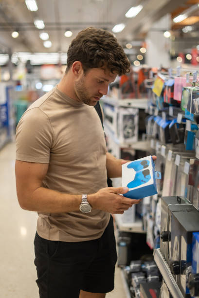 istock Man picking gamepad in shop 1349687465