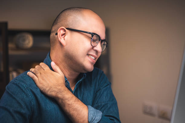 istock Young businessman work with computer late at night room. He tired and stressed needs rest. He has shoulder neck and back pain. Working hard and overtime too much going to symptom office syndrome. 1349688690
