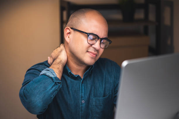 istock Young businessman work with computer late at night room. He tired and stressed needs rest. He has shoulder neck and back pain. Working hard and overtime too much going to symptom office syndrome. 1349688701