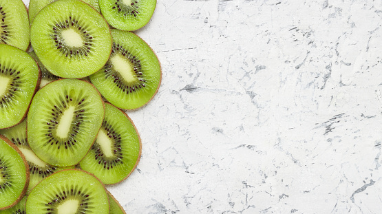 Banner with sliced kiwi fruit with copy space on concrete background.
