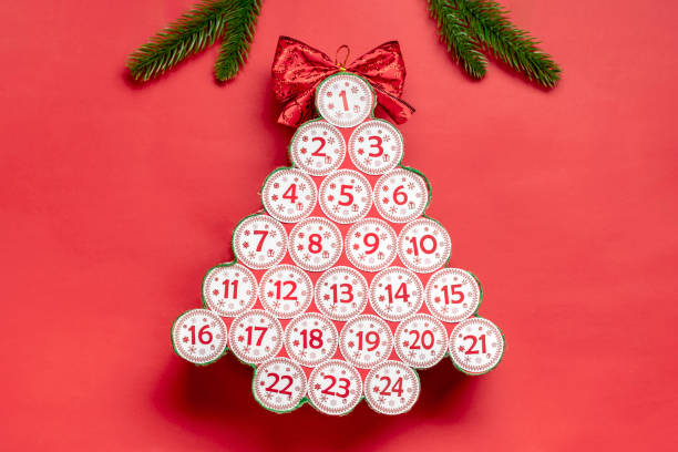 scatole regalo rosse e verdi avvolte a mano decorate con nastri, fiocchi di neve e numeri, decorazioni natalizie e decorazioni sul tavolo concetto di calendario dell'avvento di natale vista dall'alto piatto lay biglietto di auguri di natale - advent calendar christmas number red foto e immagini stock