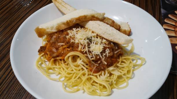 istock Spaghetti with sauce and bread on a white porcelain plate 1349696422