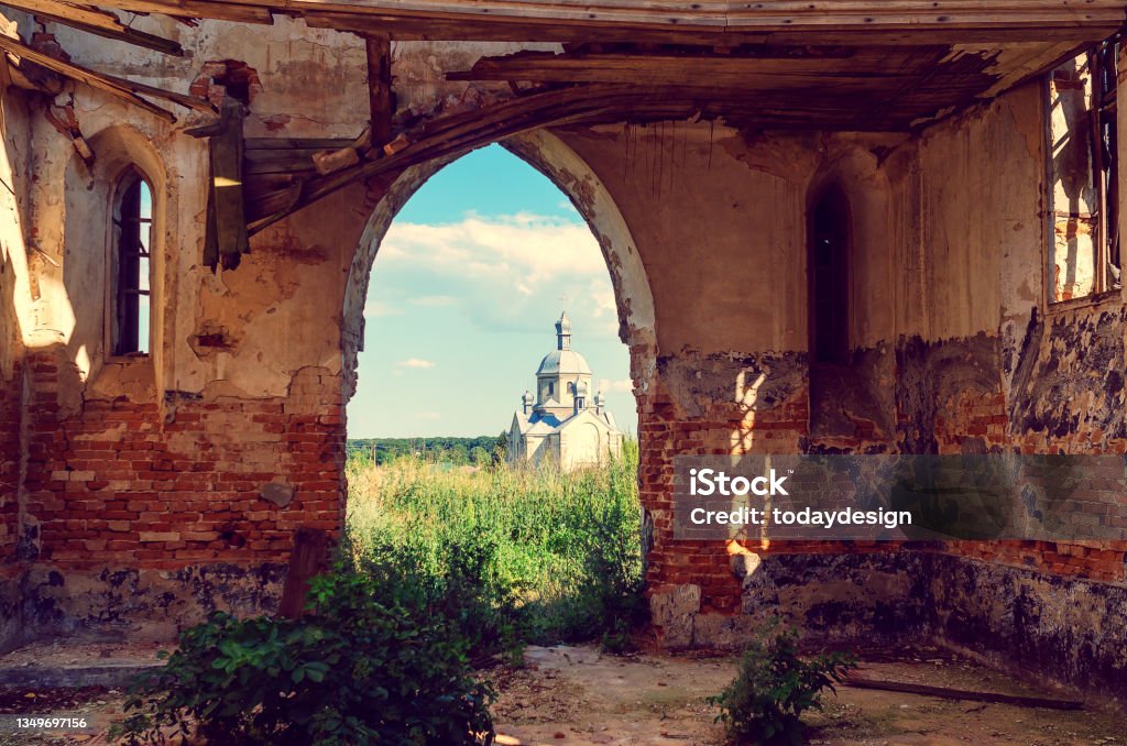 Orthodox Church through the ruins of the Catholic Church Orthodox Church through the ruins of Catholic Church Environmental Conservation Stock Photo