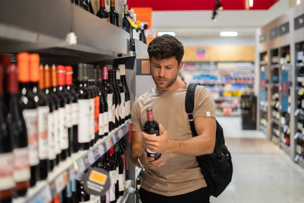 istock Man buying wine in shop 1349699556