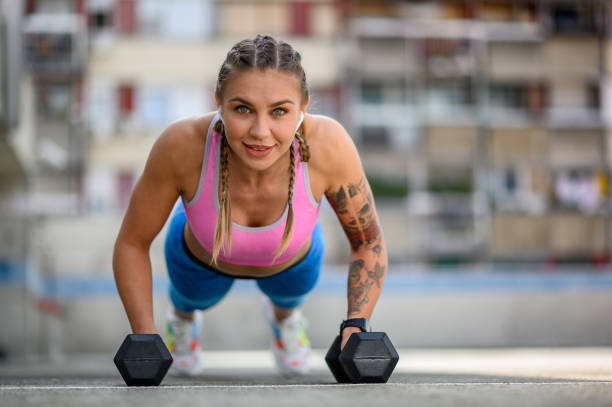 istock Woman training outside while using dumbbells and airpods 1349700276